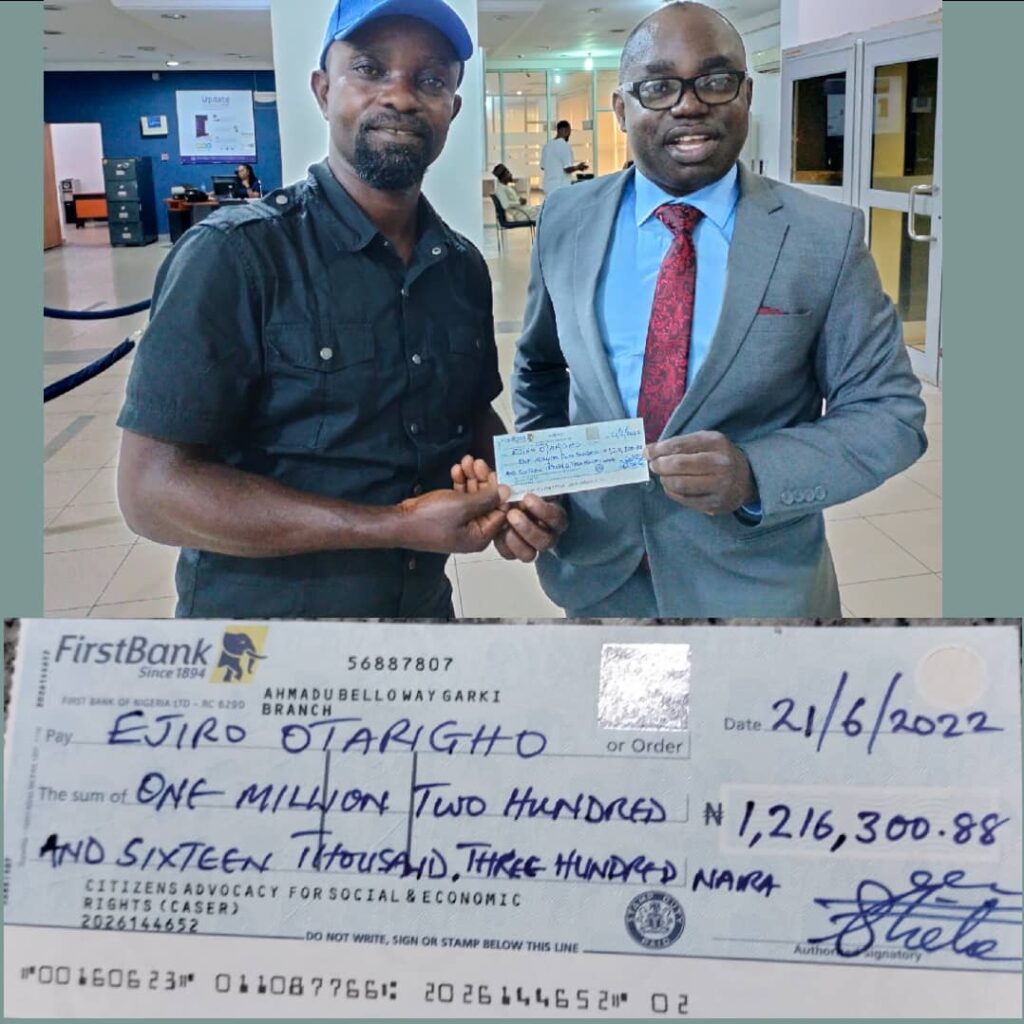 Ejiro Otarigho receiving a cheque from Frank Tietie in Abuja