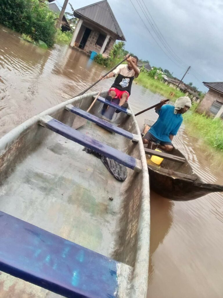 Two young men paddling canoes on the flooded streets of Isua-Joinkarama Community in Engenni Kingdom, Ahoada-West LGA of Rivers State. PHOTO CREDIT: @AskPHPeople 