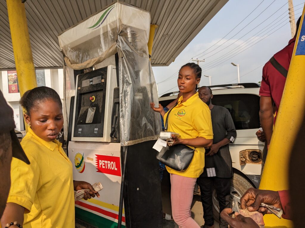 A saleslady selling fuel to the bike man at the NNPC station