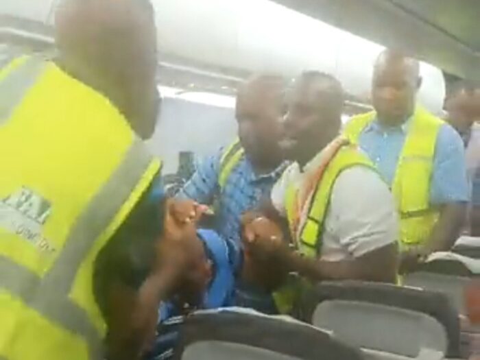 Unknown man dragged from plane