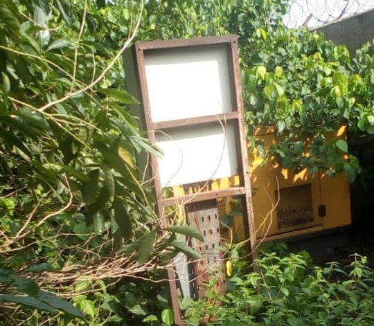 A generator overgrown by weeds