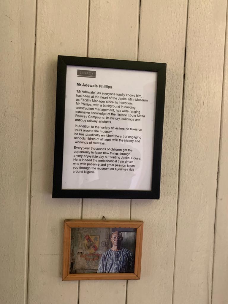 A photo and plaque with a brief history of Philip Adewale, the facility manager, hung in Jaekel House