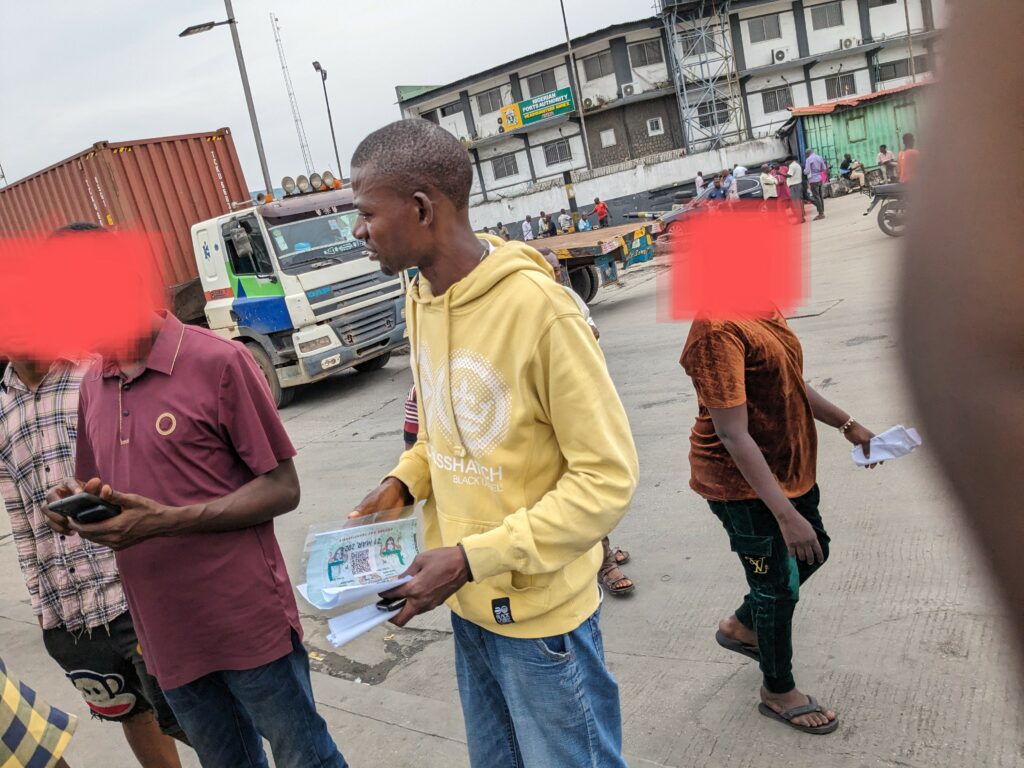Olalekan holding some stickers procured on behalf of his clients at Apapa Wharf